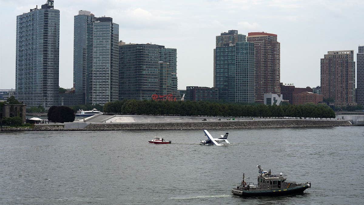 Wide view of emergency responders surrounding a seaplane in New York City's East River