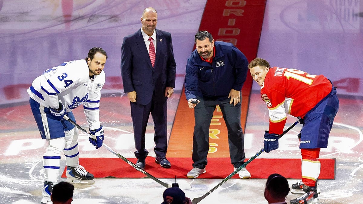 Auston Matthews, Bill Zito, Teddy Richards and Matthew Tkachuk pose with a puck at Amerant Bank Arena.