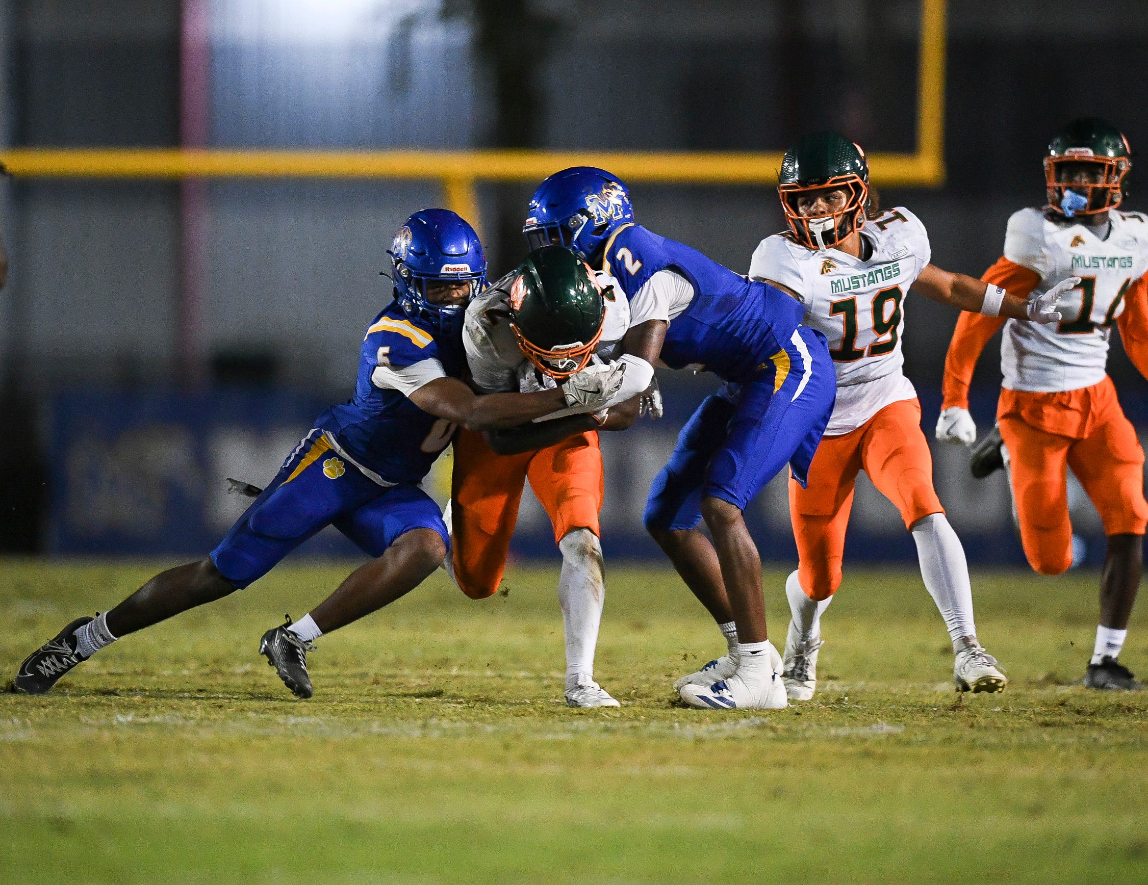 Martin County's Amarion Queen (2) and Jeromie King (5) tackle McArthur's Jaylyn Jones (4) in a Region 4-5A quarterfinal football game, Nov. 14, 2025, at Martin County High School. McArthur won 41-13.