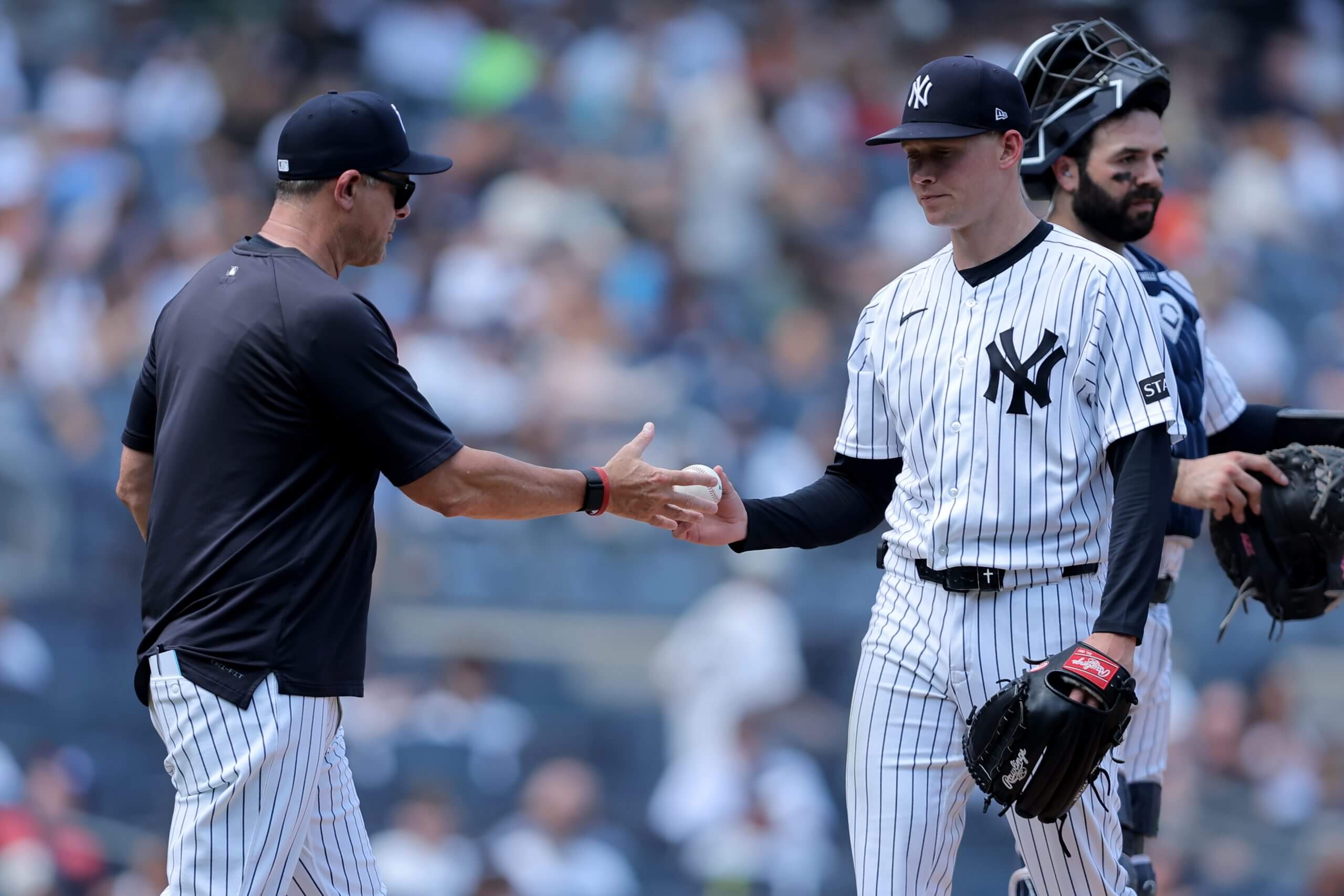 Manager Aaron Boone accepts the ball from starting pitcher Will Warren as he pulls Warren from the game.