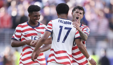 Three U.S. players celebrating on the field, one shouting with arms raised, another smiling and reaching toward him.