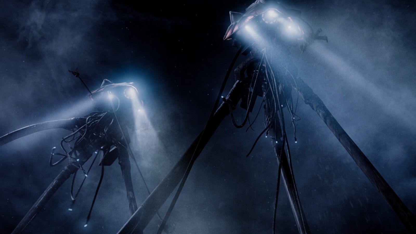 Still from the sci-fi movie "World of the Worlds" (2005). Giant tripod mechanical-looking aliens search using bright lights in the dark.