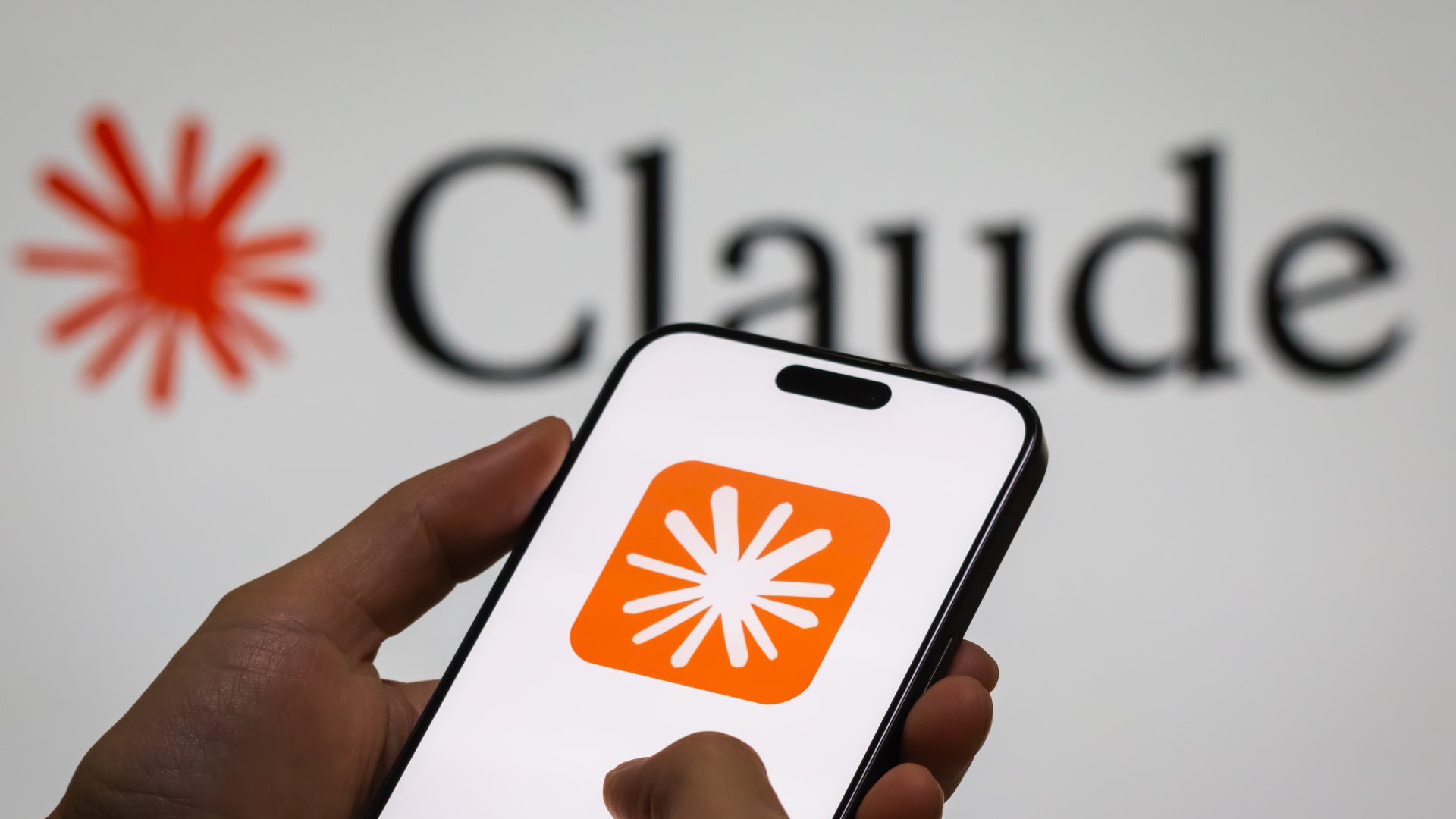 CHONGQING, CHINA - DECEMBER 29: In this photo illustration, a person holds a smartphone displaying the logo of “Claude,” an AI language model by Anthropic, with the company’s logo visible in the background, illustrating the rapid development and adoption of generative AI technologies, on December 29, 2024 in Chongqing, China. Artificial Intelligence (AI) has become a cornerstone of China’s strategic ambitions, with the government aiming to establish the country as a global leader in AI by 2030.