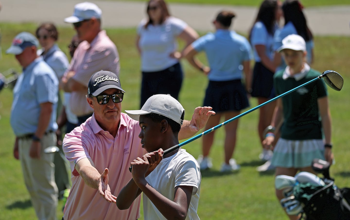 Grason Agbai received instruction from golf pro Bill Barton about the driver during youth golf clinic at the George Wright Golf Course in Hyde Park. 