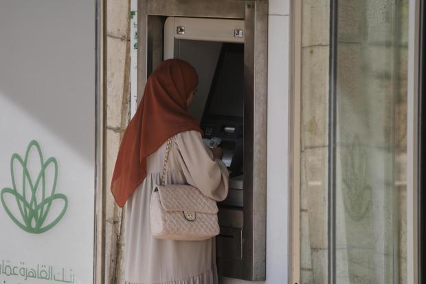 A Palestinian woman withdraws money from an ATM in the West Bank city of Bethlehem.