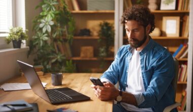 A man uses the phone as he sits by the desk