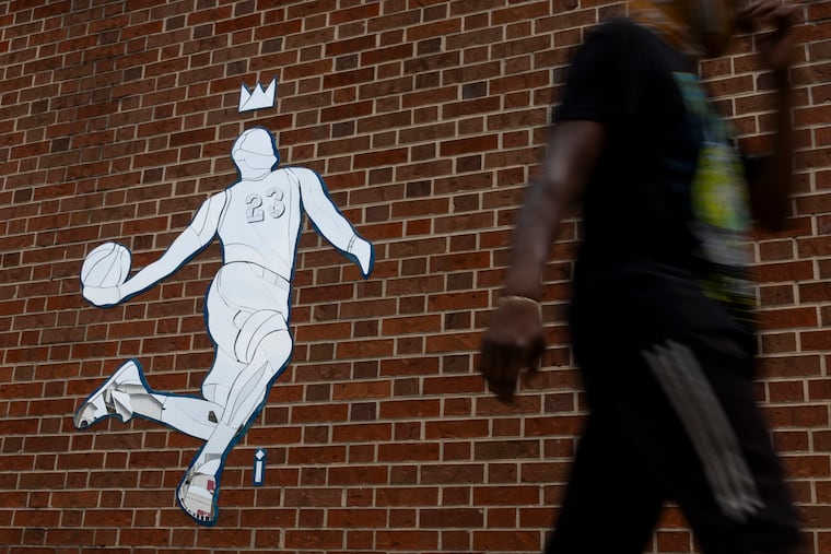 People walking by the LeBron James mosaic on 8th and Market Street on Tuesday.