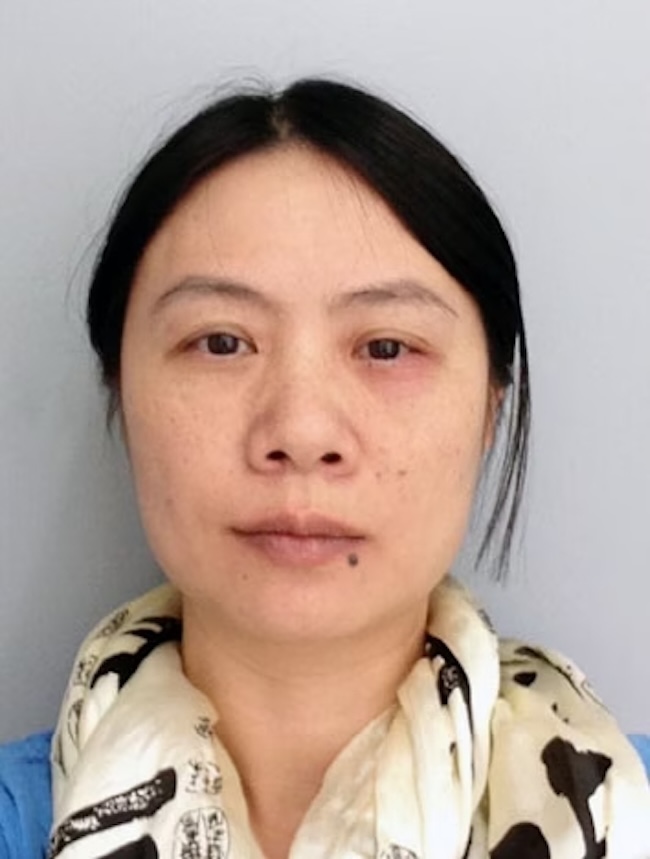 Serious-looking young woman with pulled-back black hair, wearing a scarf.