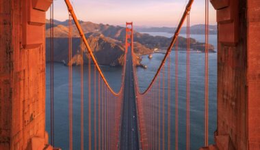 an aerial photograph of the Golden Gate Bridge in San Francisco framed through one of its tower