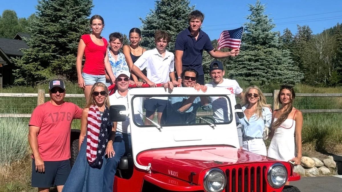 Ali Larter poses with family and friends dressed in red, white and blue beside a red Jeep during a Fourth of July celebration in the mountains.
