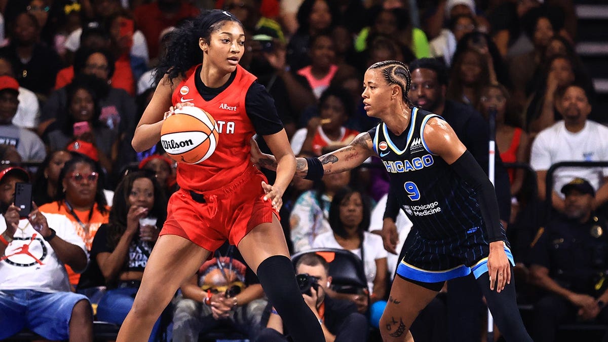 Angel Reese passes the ball as Natasha Cloud defends during a game in Atlanta.
