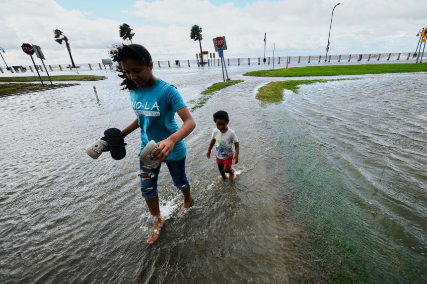 Residents walk in the floodwaters along Lake Pontchartrain in New Orleans as Tropical Storm Bertha approaches the Louisiana coast on Wednesday, July 22.