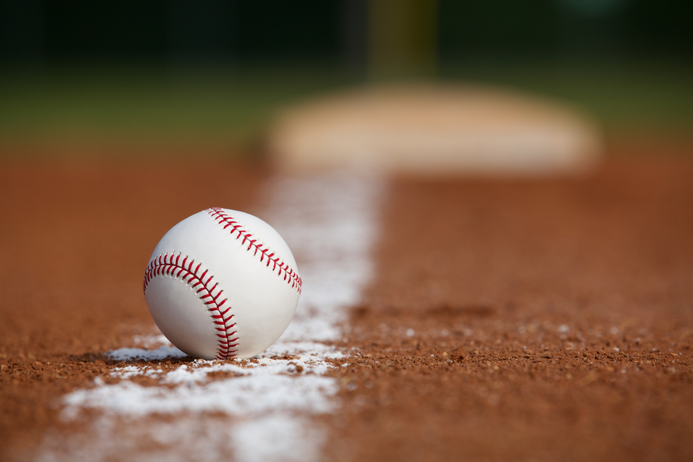 Baseball resting on the foul line on a baseball field