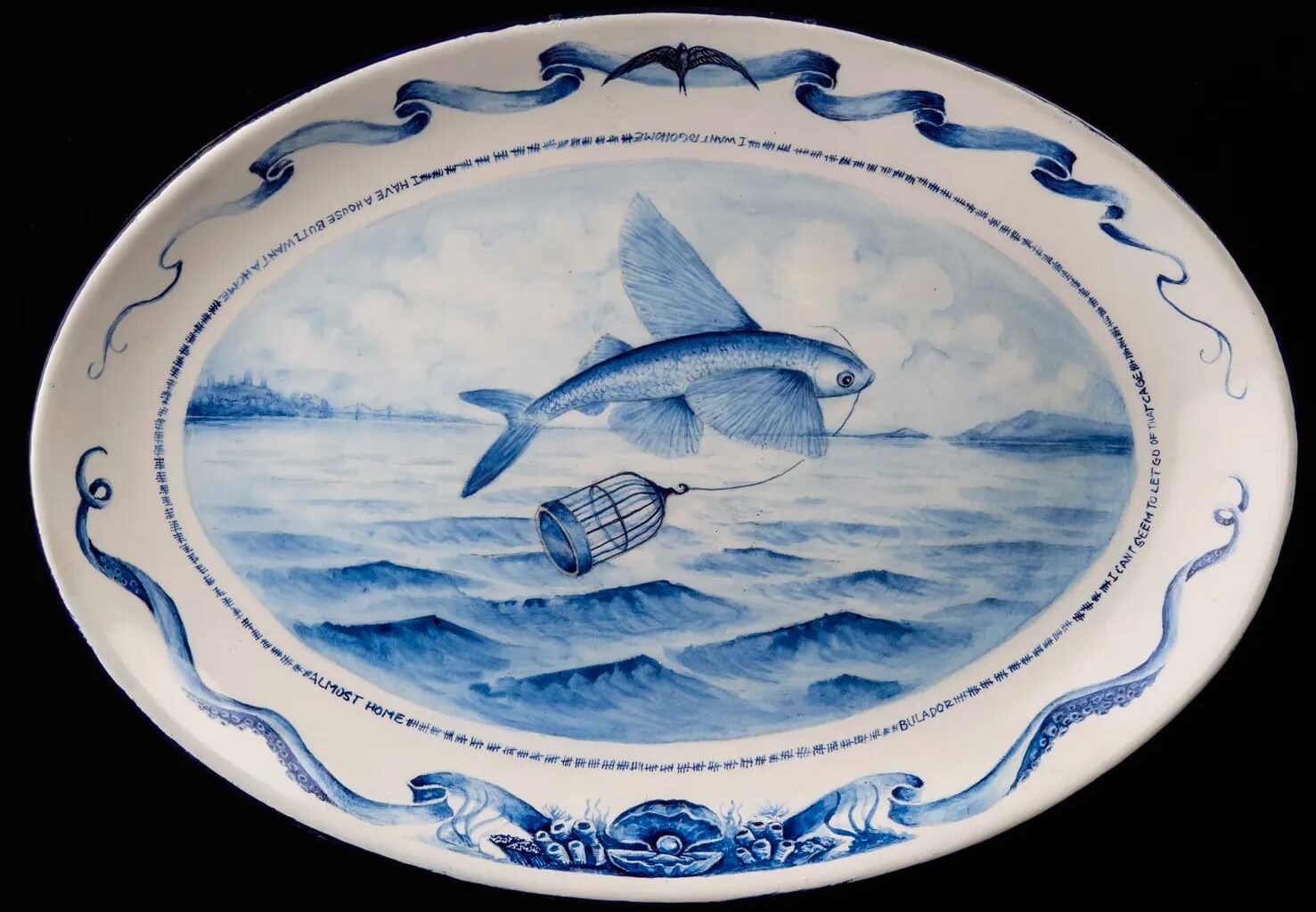 a white plate with a blue painting of a fish jumping from the water with a bird cage in its mouth