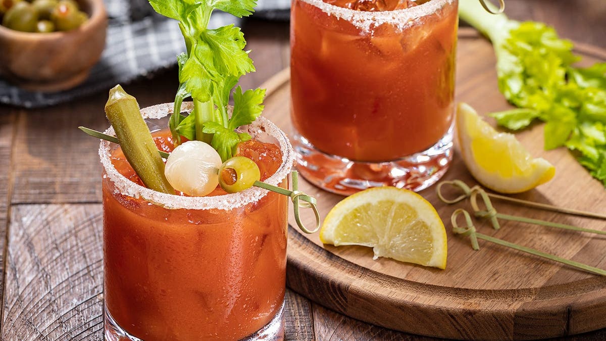 Two bloody Marys sit on a table.