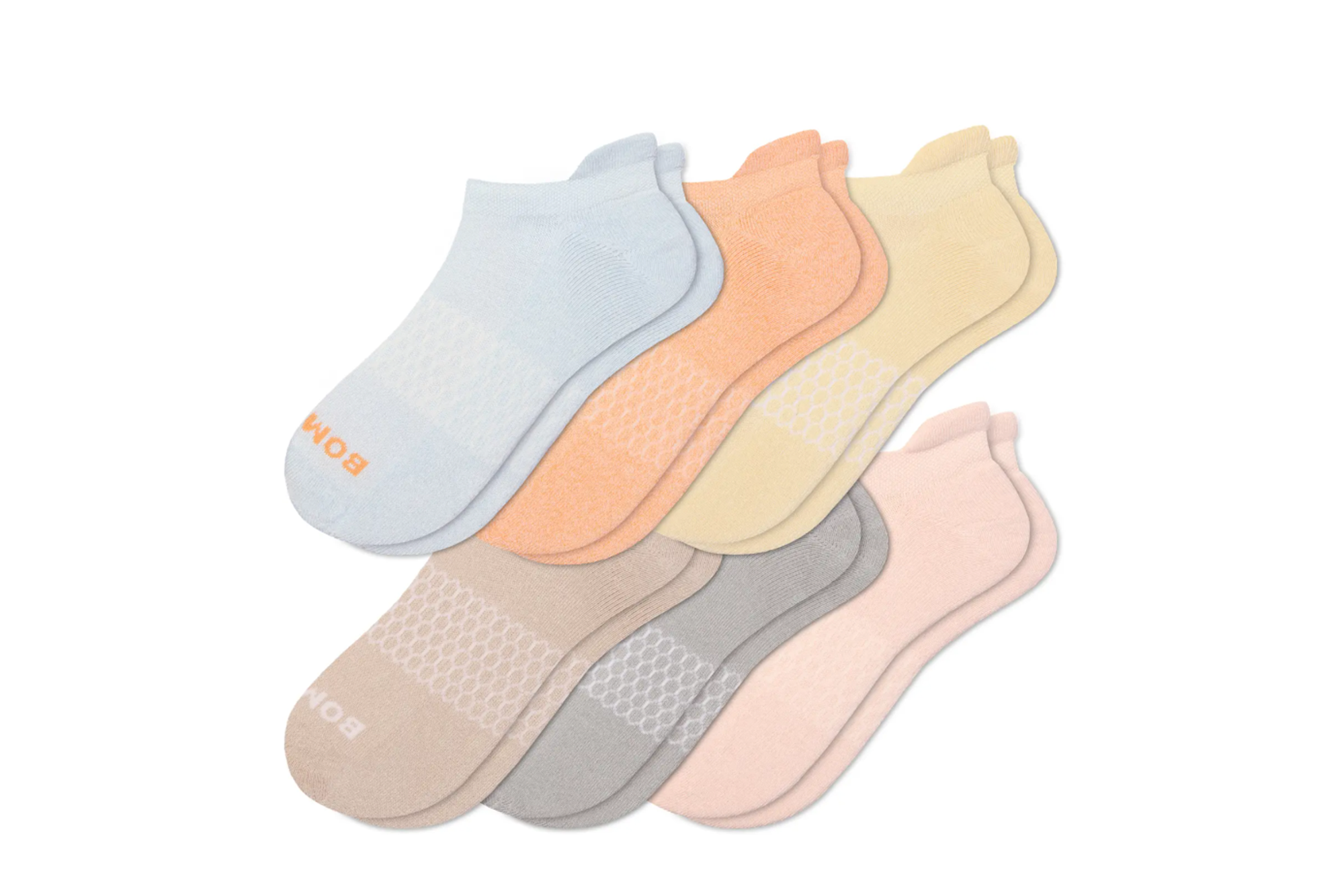 Six pairs of Bombas ankle socks in light blue, peach, yellow, beige, grey, and pink.