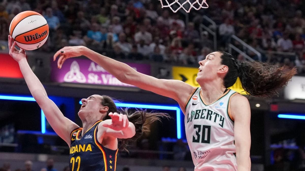 Caitlin Clark shoots against Breanna Stewart at Gainbridge Fieldhouse.