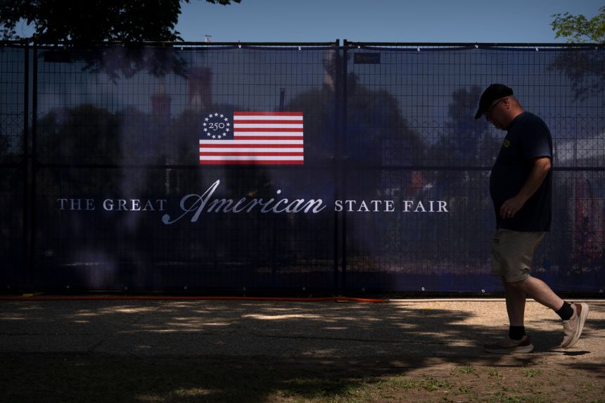 A visitor walks past signage for the Great American State Fair on the National Mall, on June 30, in Washington.