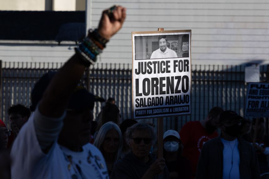 A demonstrator carries a sign Tuesday at a protest in San Francisco in response to two fatal shootings by ICE agents.