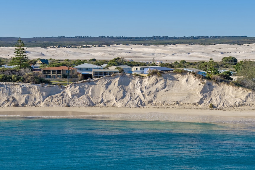 The ocean in front of a severley eroded dune.