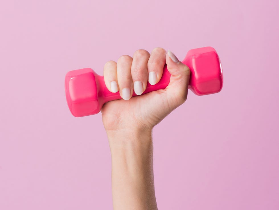 cropped shot of woman holding dumbbell isolated on pink cropped shot of woman holding dumbbell isolated on pink