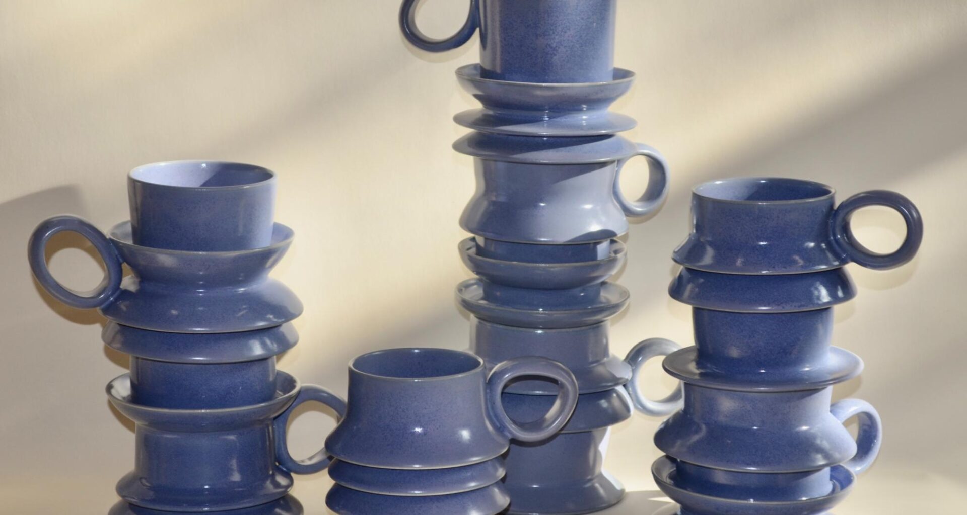 a collection of periwinkle mugs with ripples on their bodies