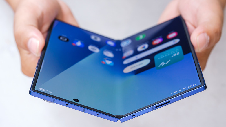 A person holding a Samsung Galaxy Z Fold 7 open showing the inner display
