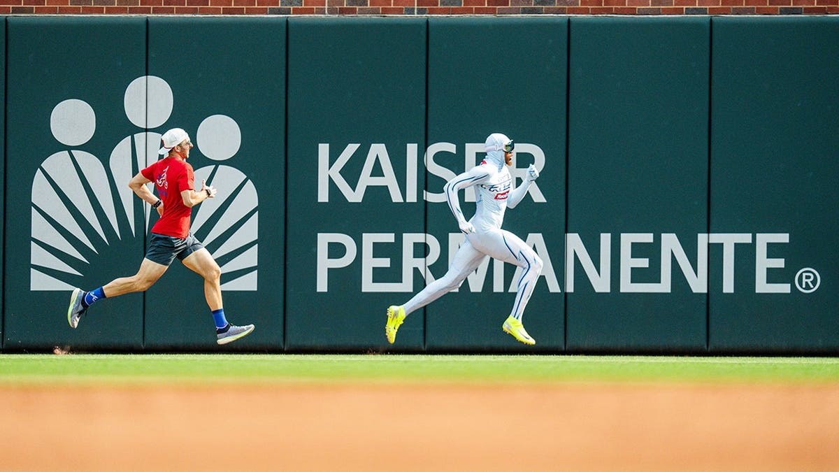 Contestant races the Freeze mascot during a baseball game at Truist Park in Atlanta.
