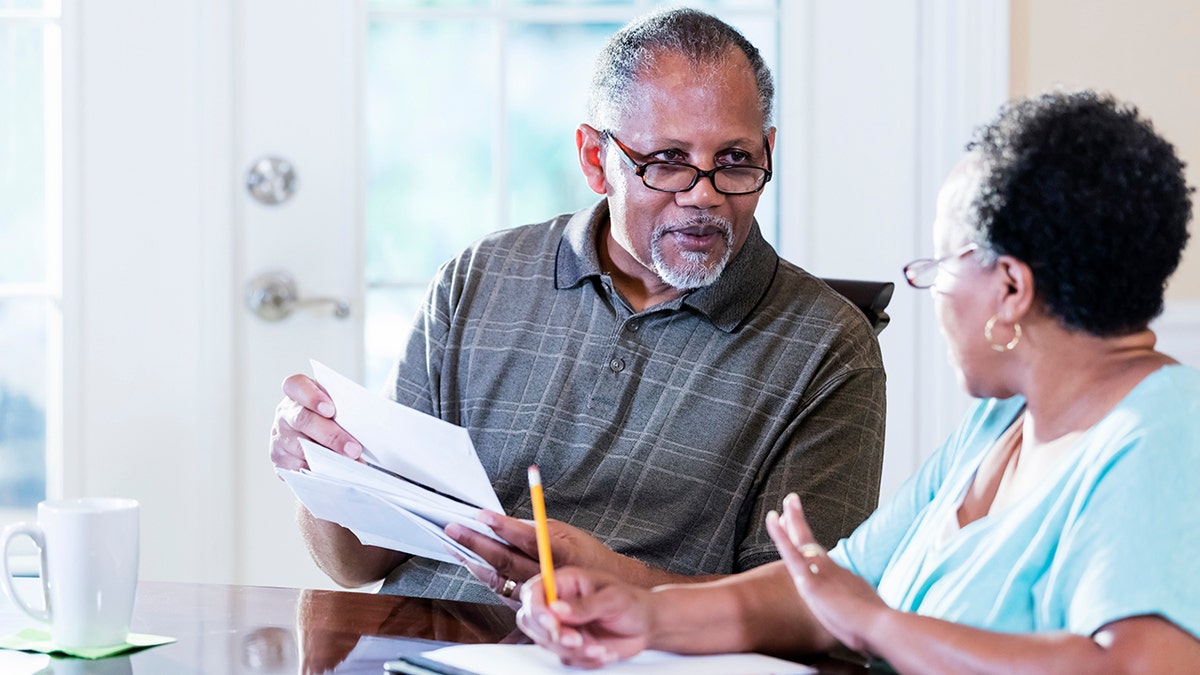 Couple looks at bills at table