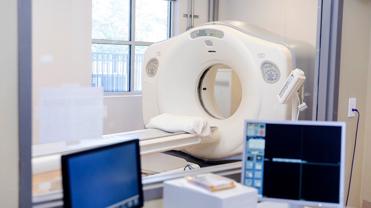 Two computer monitors are seen inside a CT scan control room.