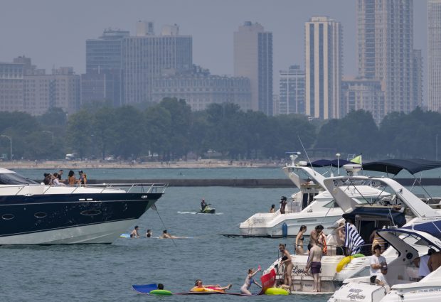 People boat in the Playpen along the Chicago lakefront under moderately hazy skies on July 19, 2026, as wildfire smoke returned to the area and air quality warnings were issued. (Brian Cassella/Chicago Tribune)