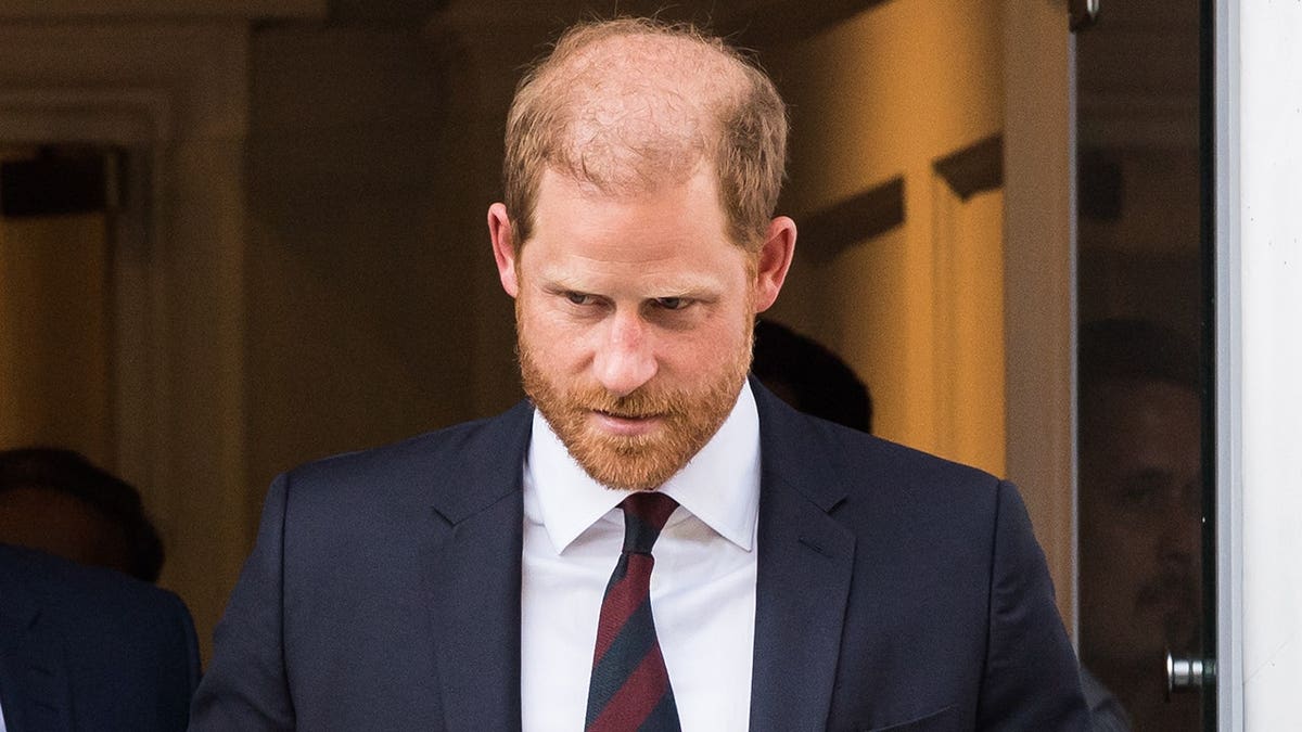 Close-up of Prince Harry in a suit looking down.