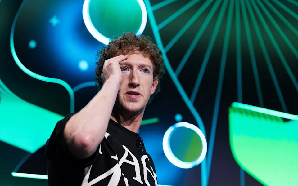 Meta's CEO Mark Zuckerberg mimics virtual reality glasses during a live recording panel at Acquired, a technology podcast, at the Chase Cente