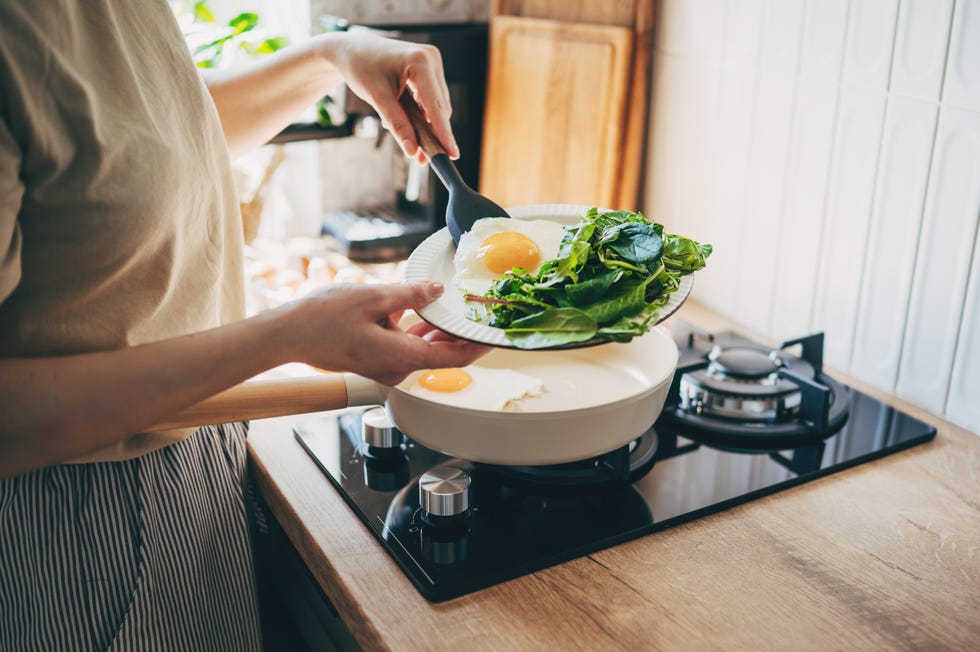 Cracking eggs into a hot pan, steam rising, cooking on a blue flame stovetop. cracking eggs into a hot pan, steam rising, cooking on a blue flame stovetop.