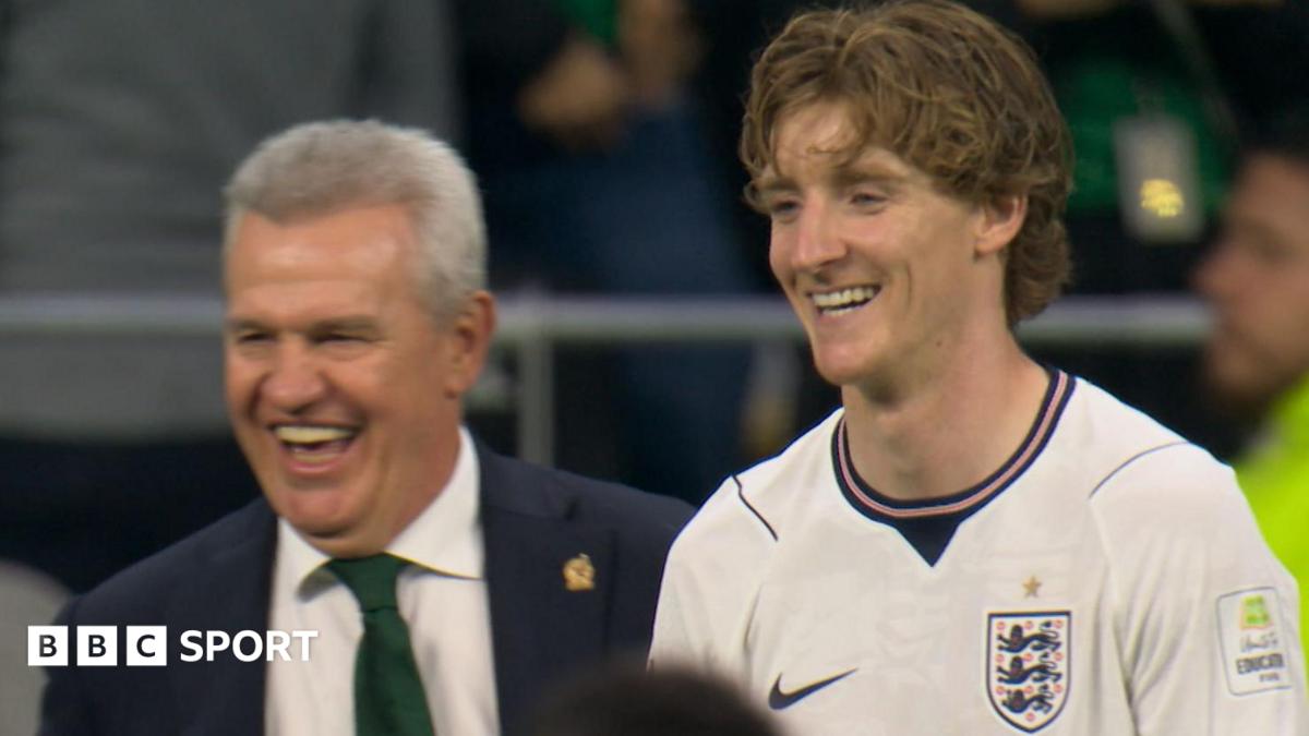 Javier Aguirre, who was manager for Mexico's game against England, and England winger Anthony Gordon share a laugh on the touchline