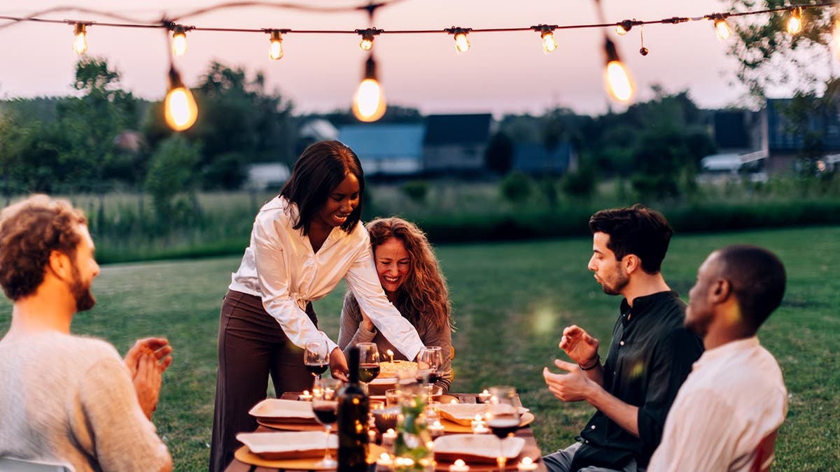 A group of friends enjoys an outdoor dinner party.