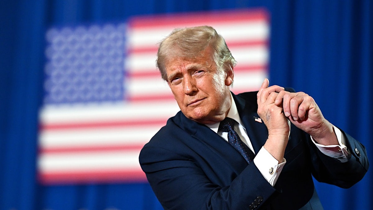 president donald trump fake swinging a golf club in front of an american flag blurred out in the background