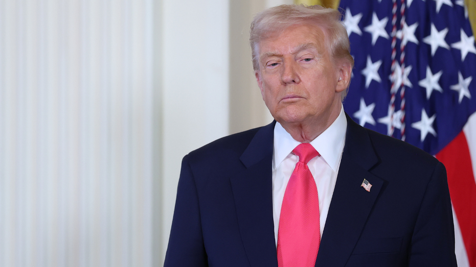 President Donald Trump stands before a U.S. flag in the White House.