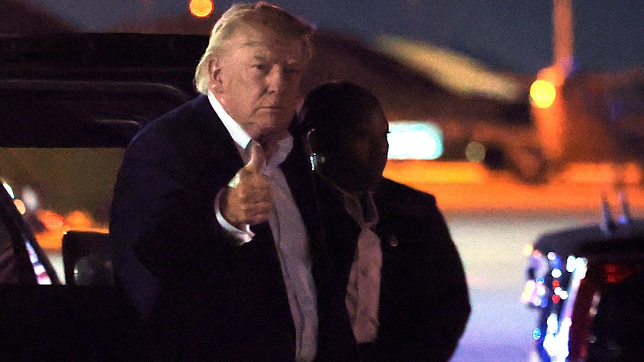 president donald trump gives a thumbs up on the tarmac
