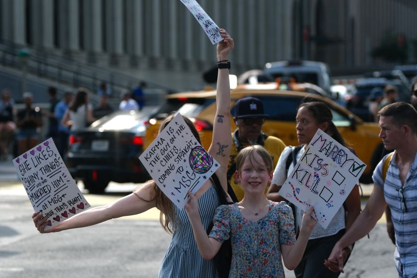 Fans hold signs outside of Madison Square Garden in New York on Friday.
