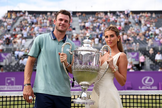 Tommy Paul of United States and girlfriend, Paige Lorenze pose for a photo with the cinch Championships 2024 winners trophy following victory against Lorenzo Musetti of Italy in the Men’s Singles Final match on Day Seven of the cinch Championship at The Queen’s Club on June 23, 2024 in London, England.]