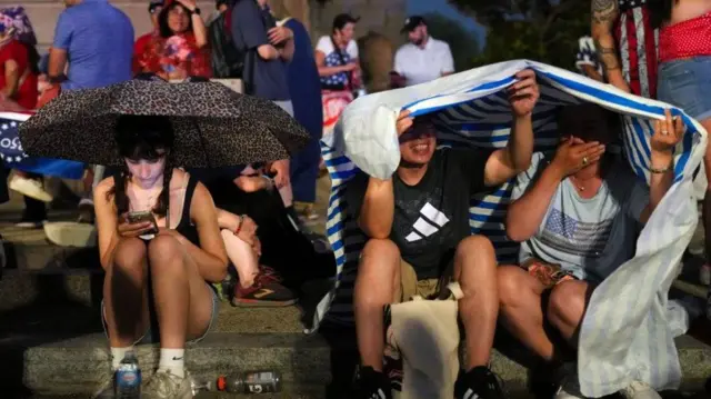 Pipo hide from di rain amid stormy weather ahead of one Fourth of July rally wey feature U.S. President Donald Trump to mark di 250th anniversary of U.S. independence, for Washington, D.C., U.S., July 4, 2026.