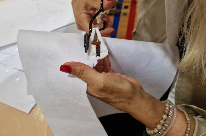 Closeup of a hand cutting out a shape from the fabric