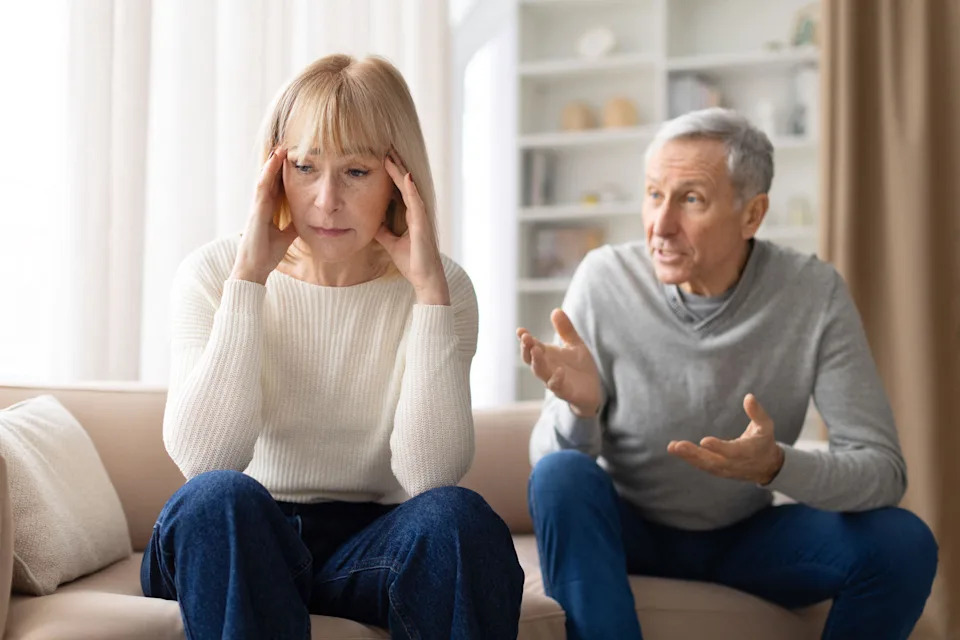3EEGJ1P Stressed senior woman sitting on sofa during argument with husband at home