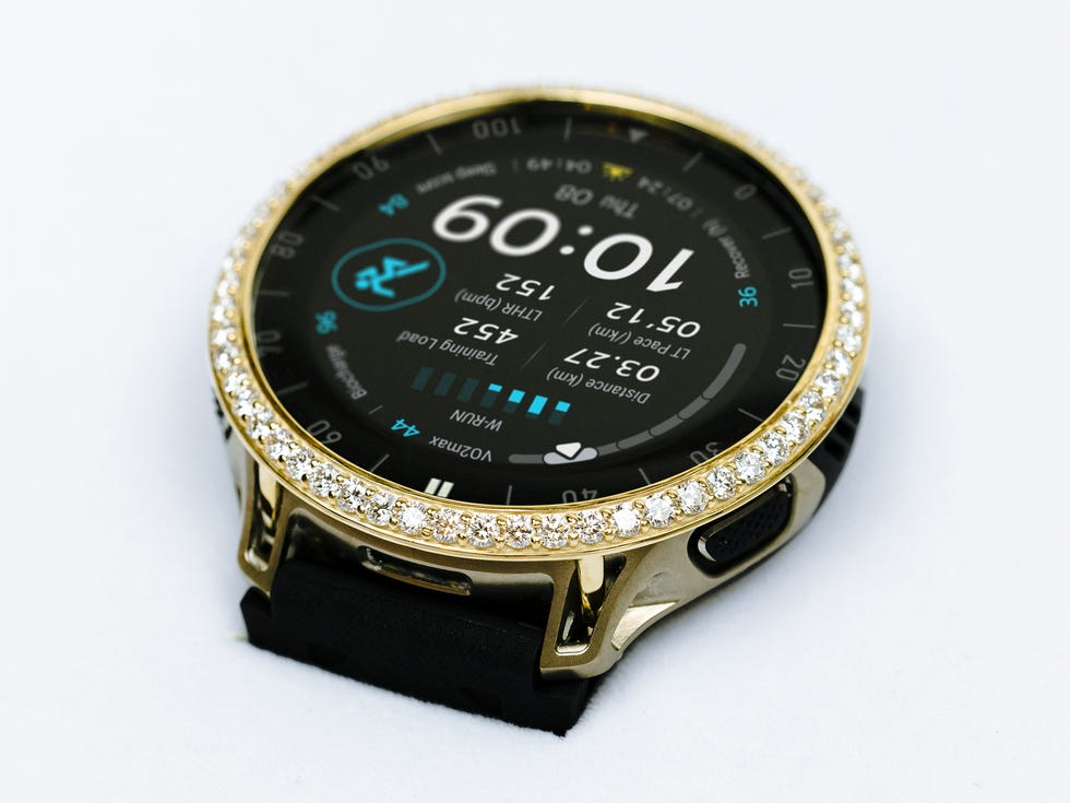 Smartwatch with a black face, gold trim, and a sparkling diamond bezel displaying various fitness metrics and time. Smartwatch with a black face, gold trim, and a sparkling diamond bezel displaying various fitness metrics and time.