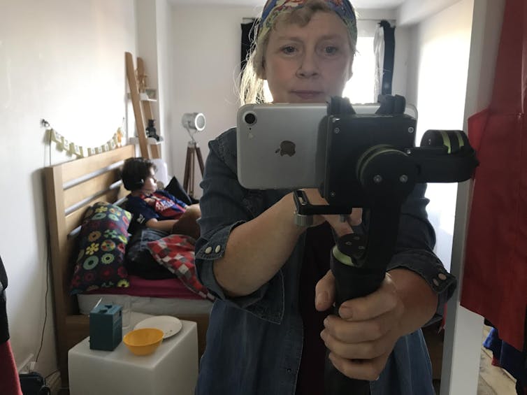 The author takes a photo in the mirror of herself with her iphone