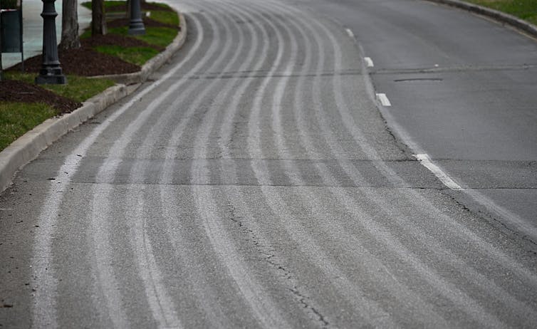 A highway lane with wet stripes running down.