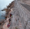 An aerial view of migrants walk next to razor wire as they try to cross Texas border in El Paso, Texas this week to seek humanitarian asylum. Meanwhile a bill aimed at overhauling immigration is on the verge of collapse in Washington.