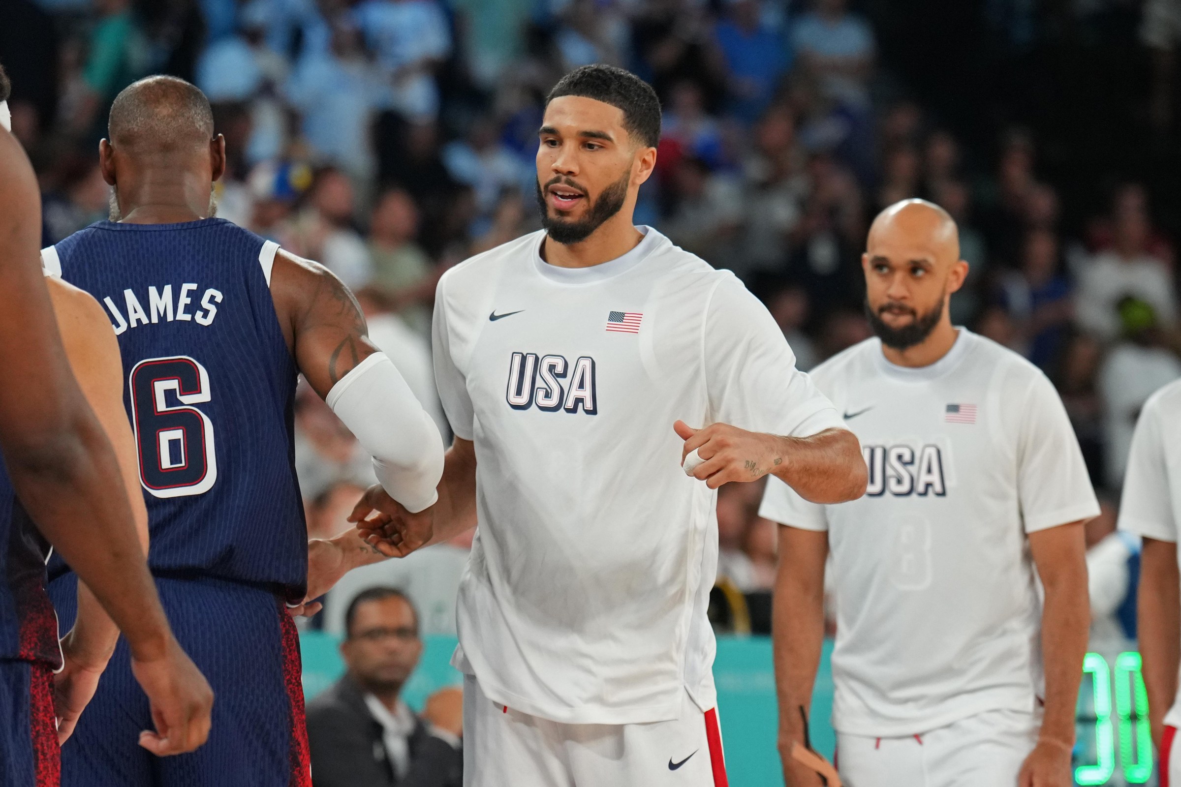 PARIS, FRANCE - AUGUST 10: LeBron James #6 of Team USA high fives Jayson Tatum #10 of Team USA while Derrick White #8 of Team USA looks on during the Men’s Gold Medal Game on August 10, 2024 at the AccorHotels Arena in Paris, France. NOTE TO USER: User expressly acknowledges and agrees that, by downloading and/or using this photograph, user is consenting to the terms and conditions of the Getty Images License Agreement. Mandatory Copyright Notice: Copyright 2024 NBAE (Photo by Jesse D. Garrabrant/NBAE via Getty Images)