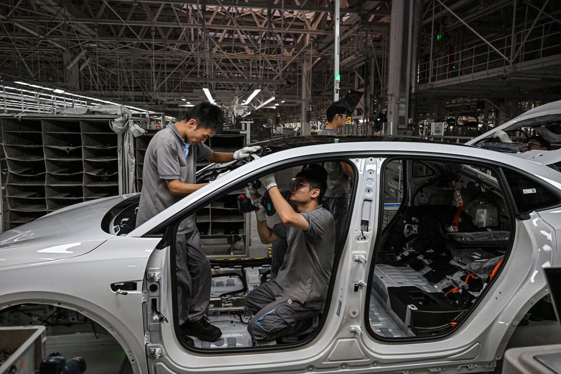 Employees work on an electric vehicle production line at a factory of Chinese automaker NIO in Hefei, in eastern China's Anhui province on September 24, 2025.